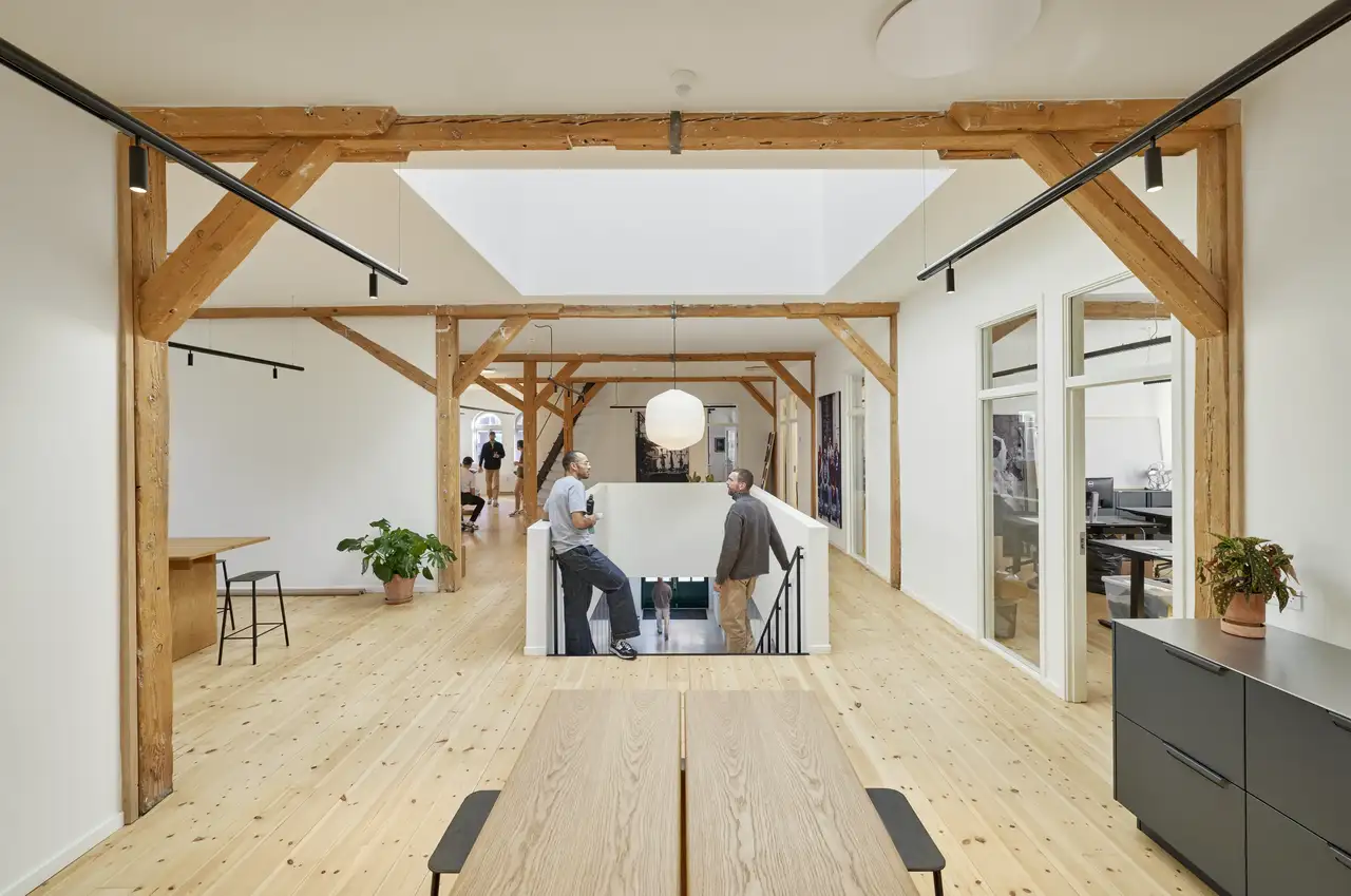 Kollegen unterhalten sich im Gemeinschaftsbereich ihres modernen Büros | VELUX Magazin