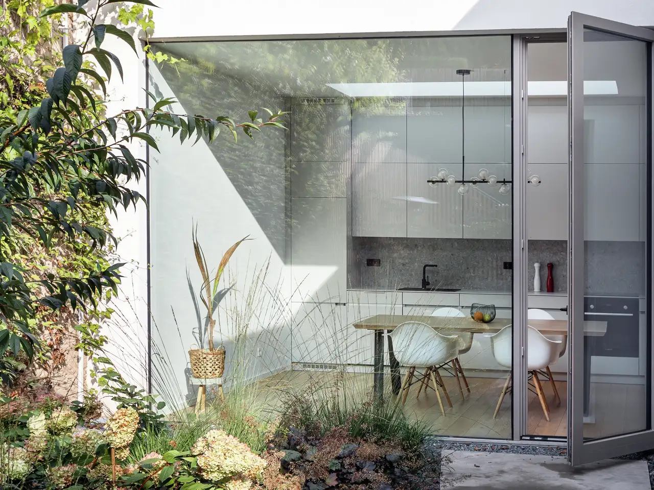 Giardino di piante sul balcone sul tetto con porta finestra aperta sulla cucina bianca lucida | Rivista VELUX