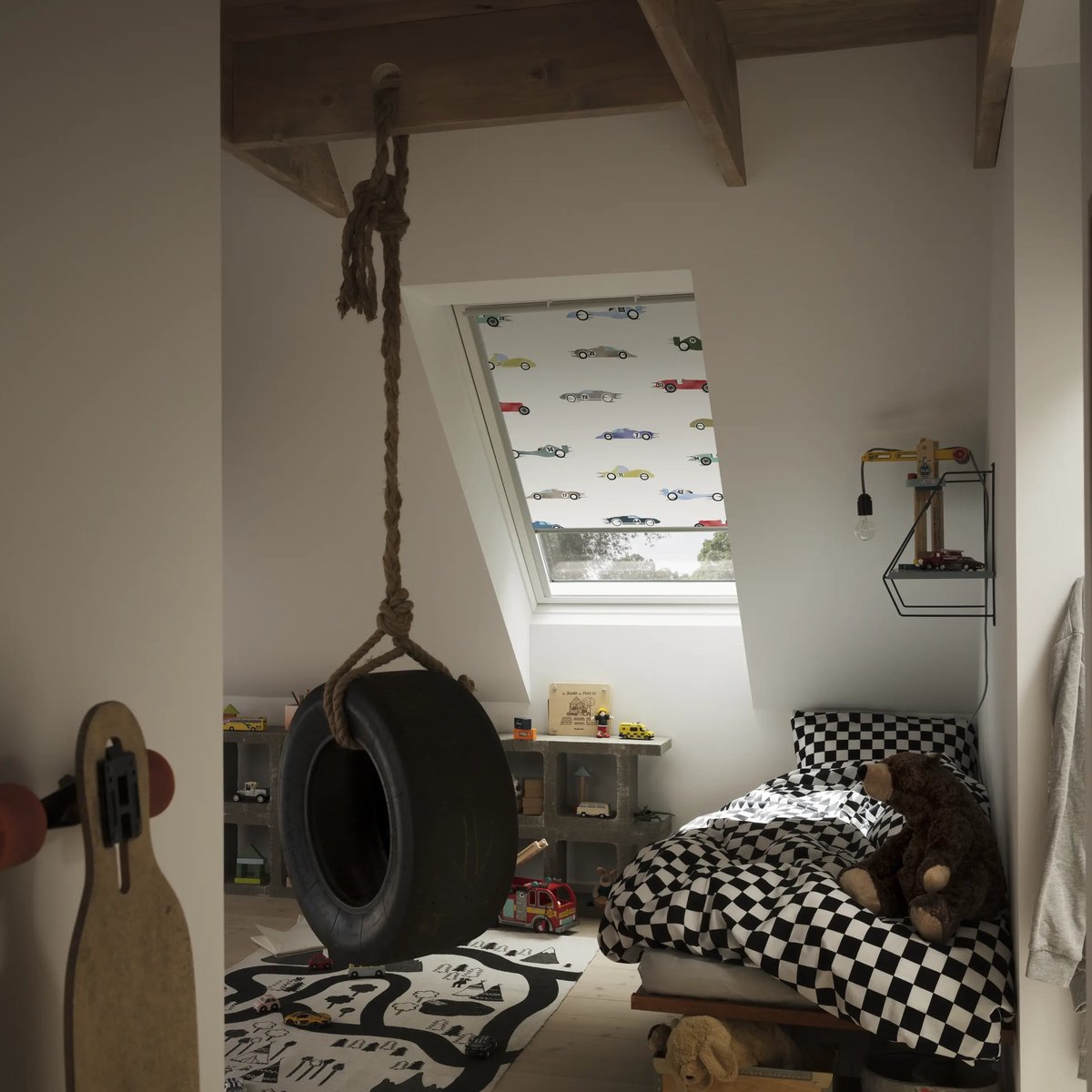Attic kids room with sloped ceiling, VELUX roof window, tire swing, and toys.