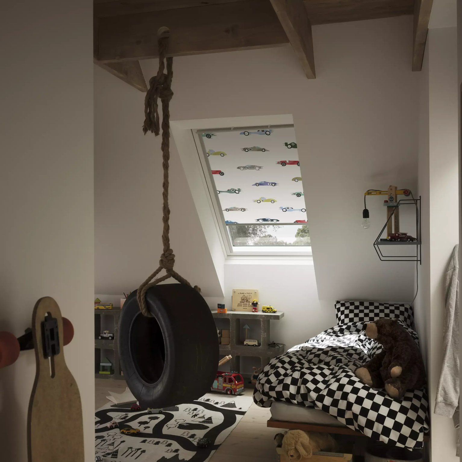 Attic kids room with sloped ceiling, VELUX roof window, tire swing, and toys.