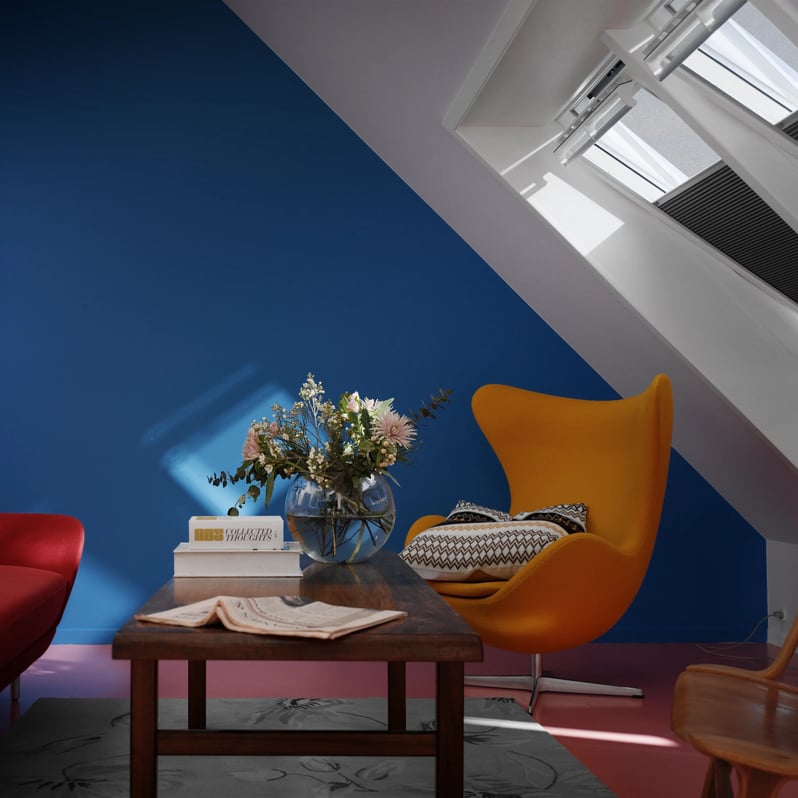 Attic living space with colorful furniture and VELUX roof window.