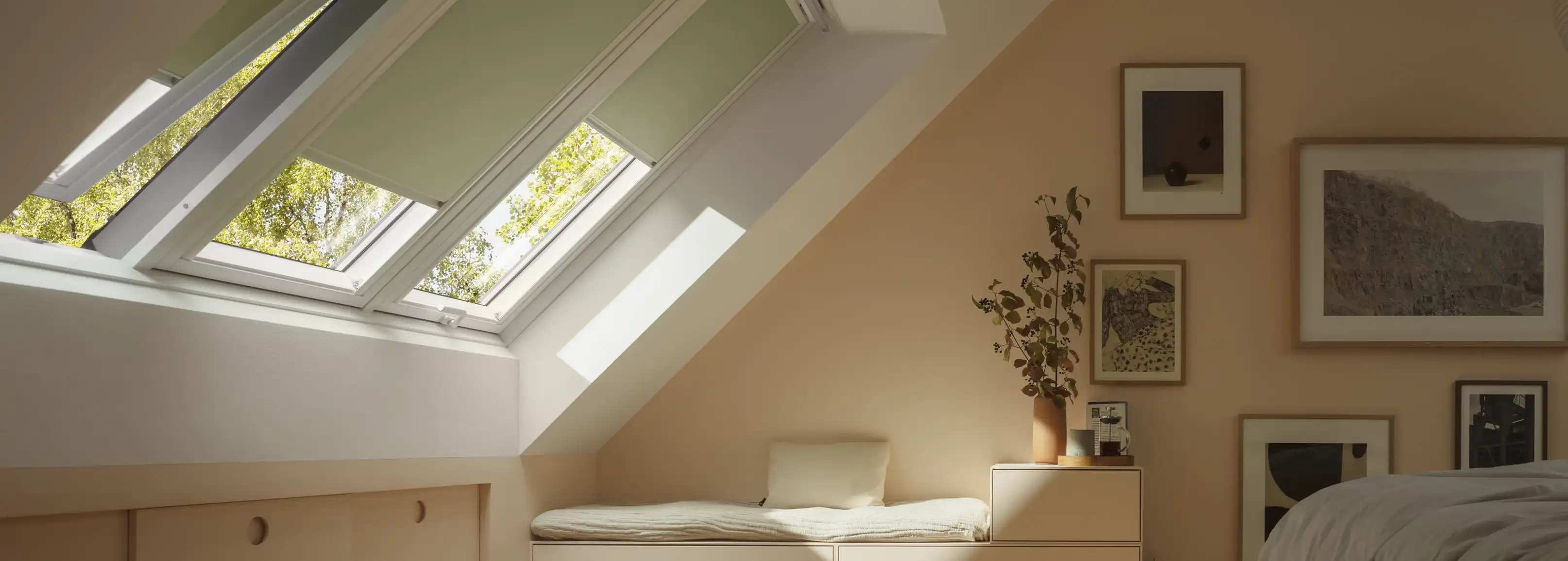 Attic bedroom with sloped ceiling and open VELUX roof window, warm decor.