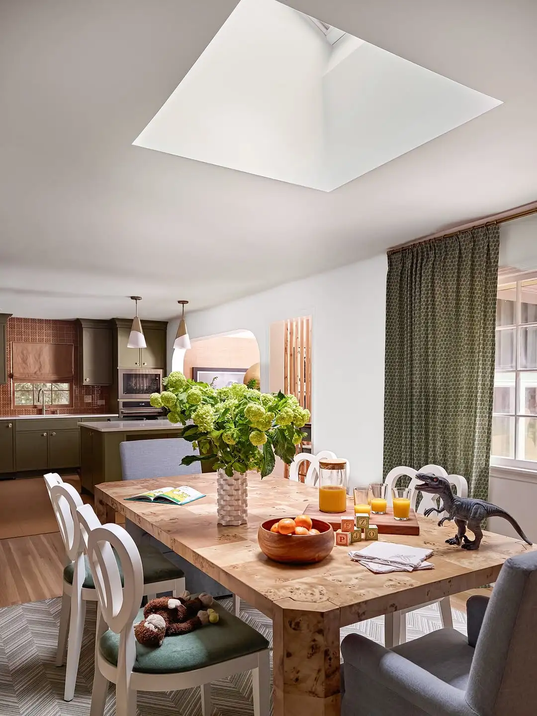 Dining room with skylight, wooden table, and natural light.