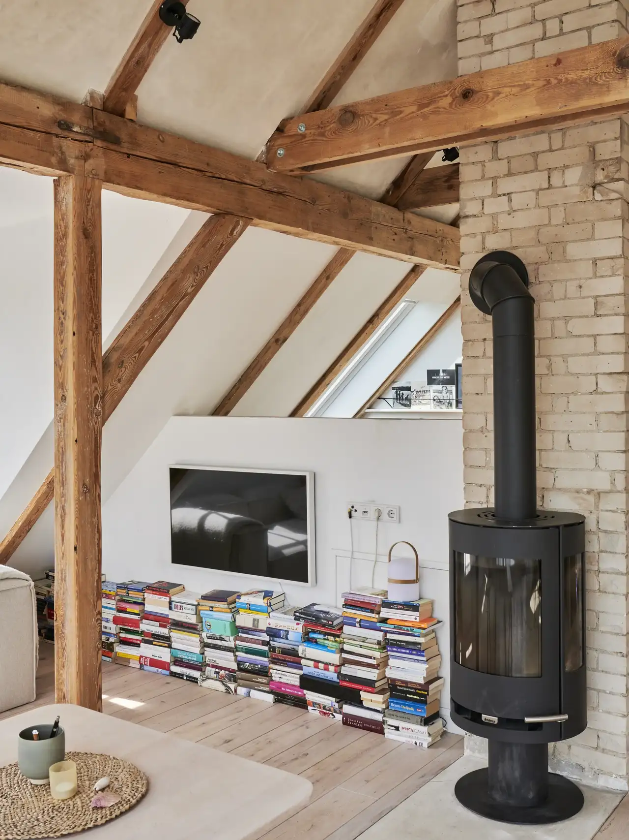 Standkamin vor Ziegelwand im  Wohnzimmer mit Buchsammlung | VELUX Magazin