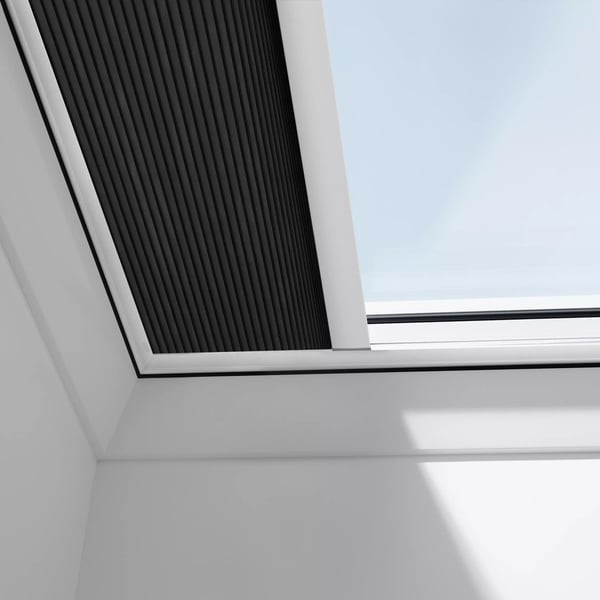 VELUX roof window with integrated blinds on a sloped ceiling.