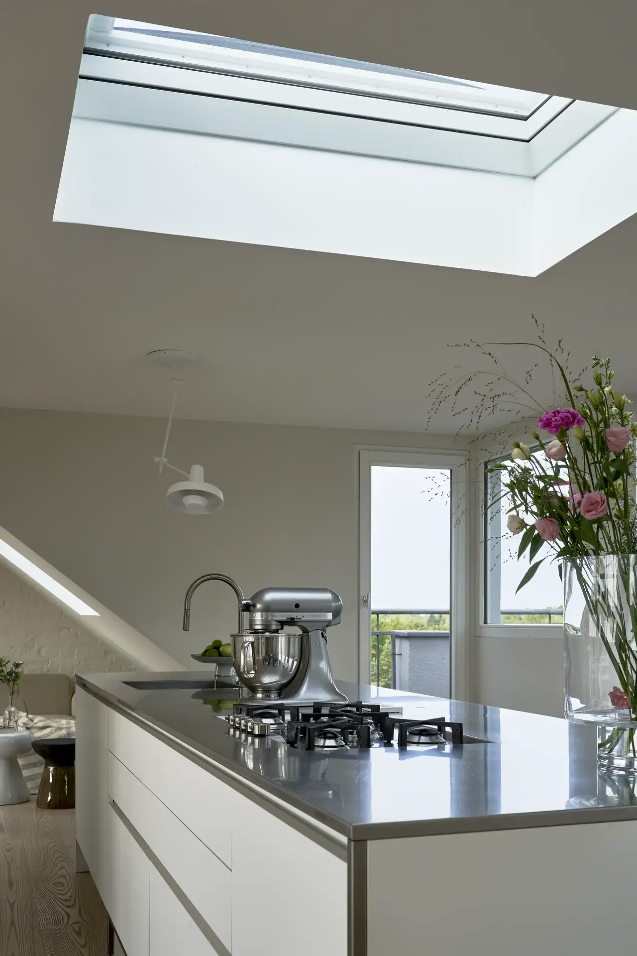 Skandinavische Kücheninsel mit hochwertigen Applikationen und Blumenvase | VELUX Magazin