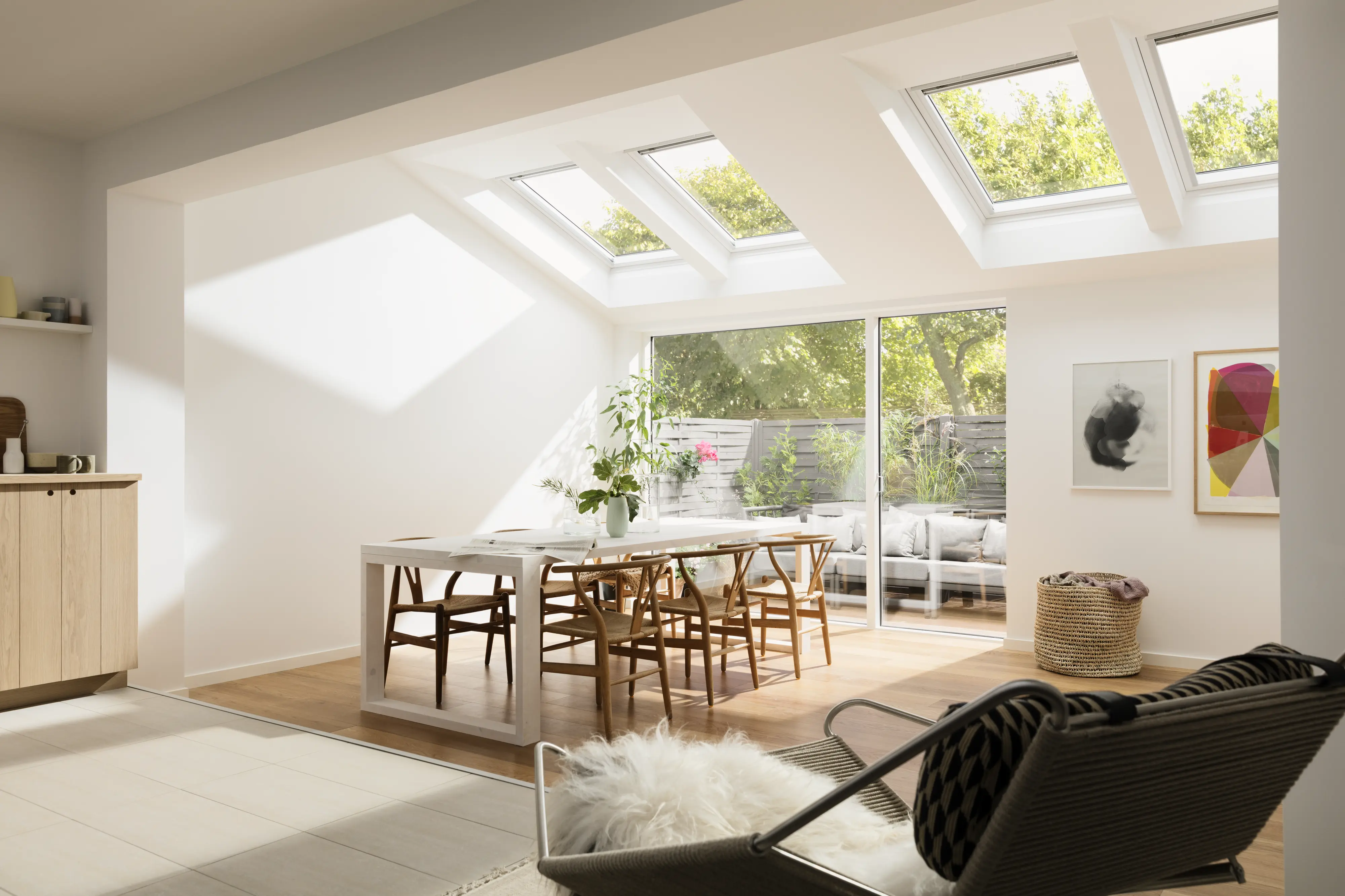 Jedáleň so strešnými oknami VELUX a posuvnými sklenenými dverami, svetlá a vzdušná.