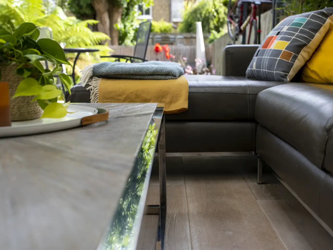 coin détente sur terrasse en toit plat avec sol foncé en lames de bois, aménagé d'une table basse et d'un canapé