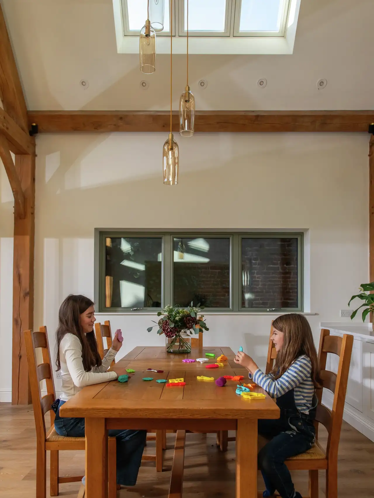 Dining room with wooden table, VELUX roof window and children playing