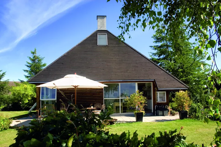 Einfamilienhaus mit VELUX Dachflächenfenster, Terrassensitzplatz und üppigem Garten.