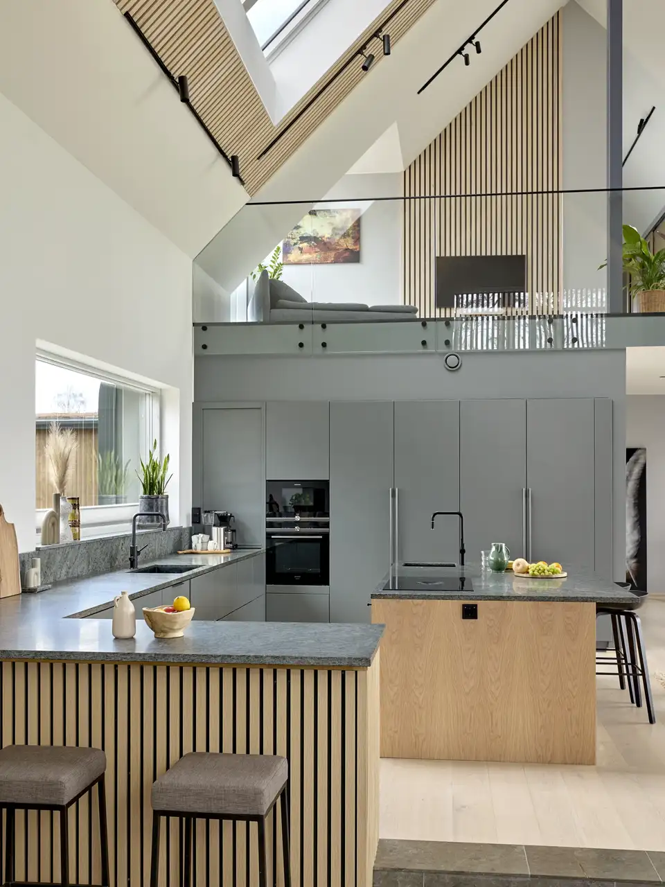 Cucina moderna con isola centrale con finestra verticale e finestre per tetti. 