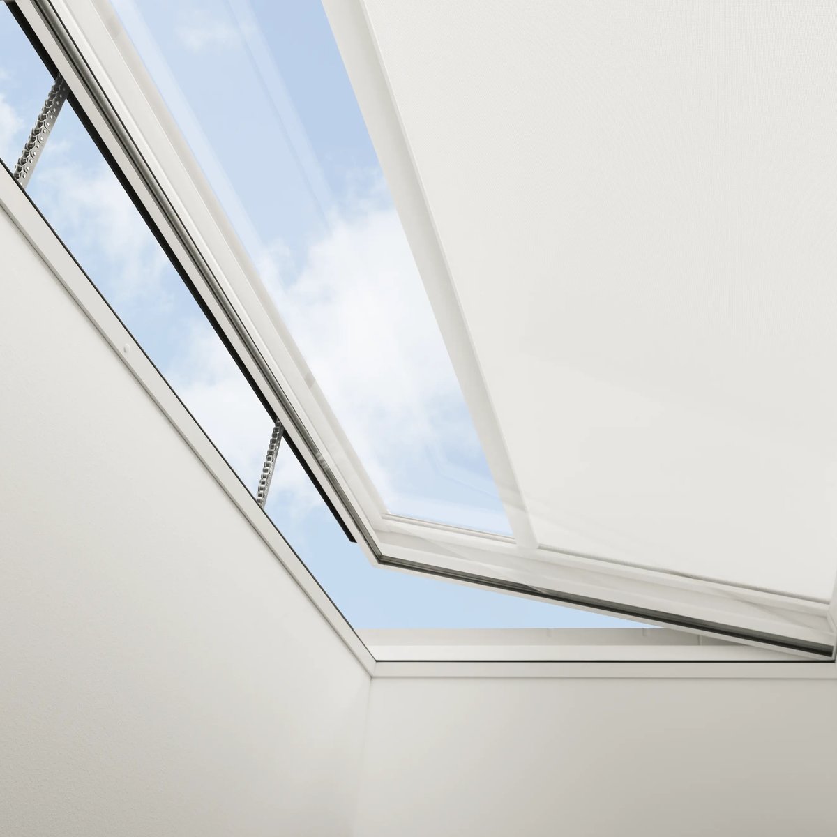 VELUX roof window open, view of sky and clouds, sloped ceiling.