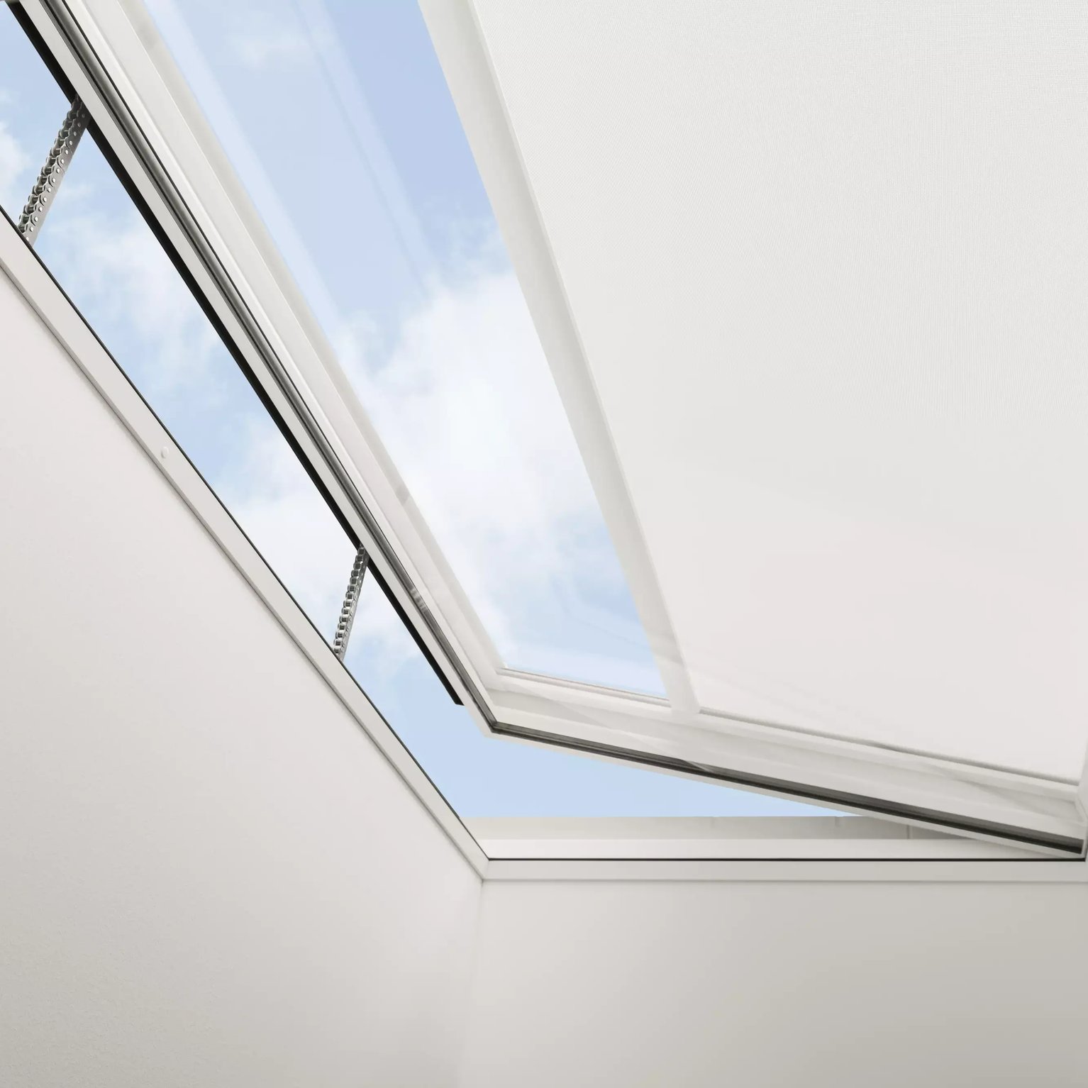VELUX roof window open, view of sky and clouds, sloped ceiling.