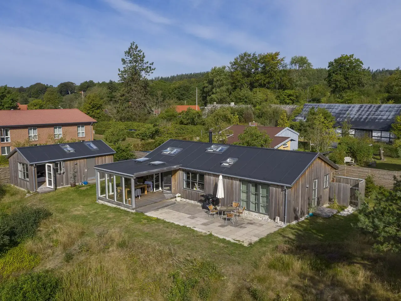 Sommerhus med tilbygning, omgivet af grønne områder