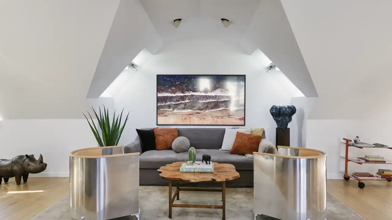 Séjour lumineux au design rétro contemporain, éclairé par la lumière naturelle provenant de fenêtres de toit.