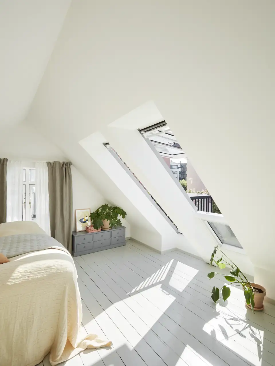 Chambre sous combles avec fenêtre de toit et balcon