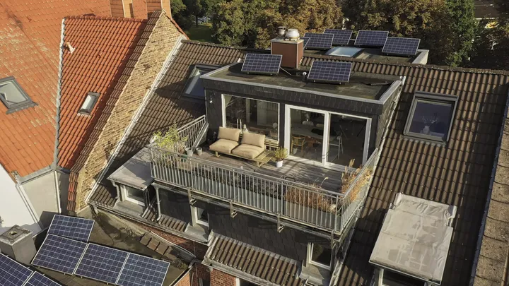 Städtische Verlängerung mit Terrasse, VELUX-Fenstern und Solarpaneelen, die modernes und traditionelles Design verbindet.