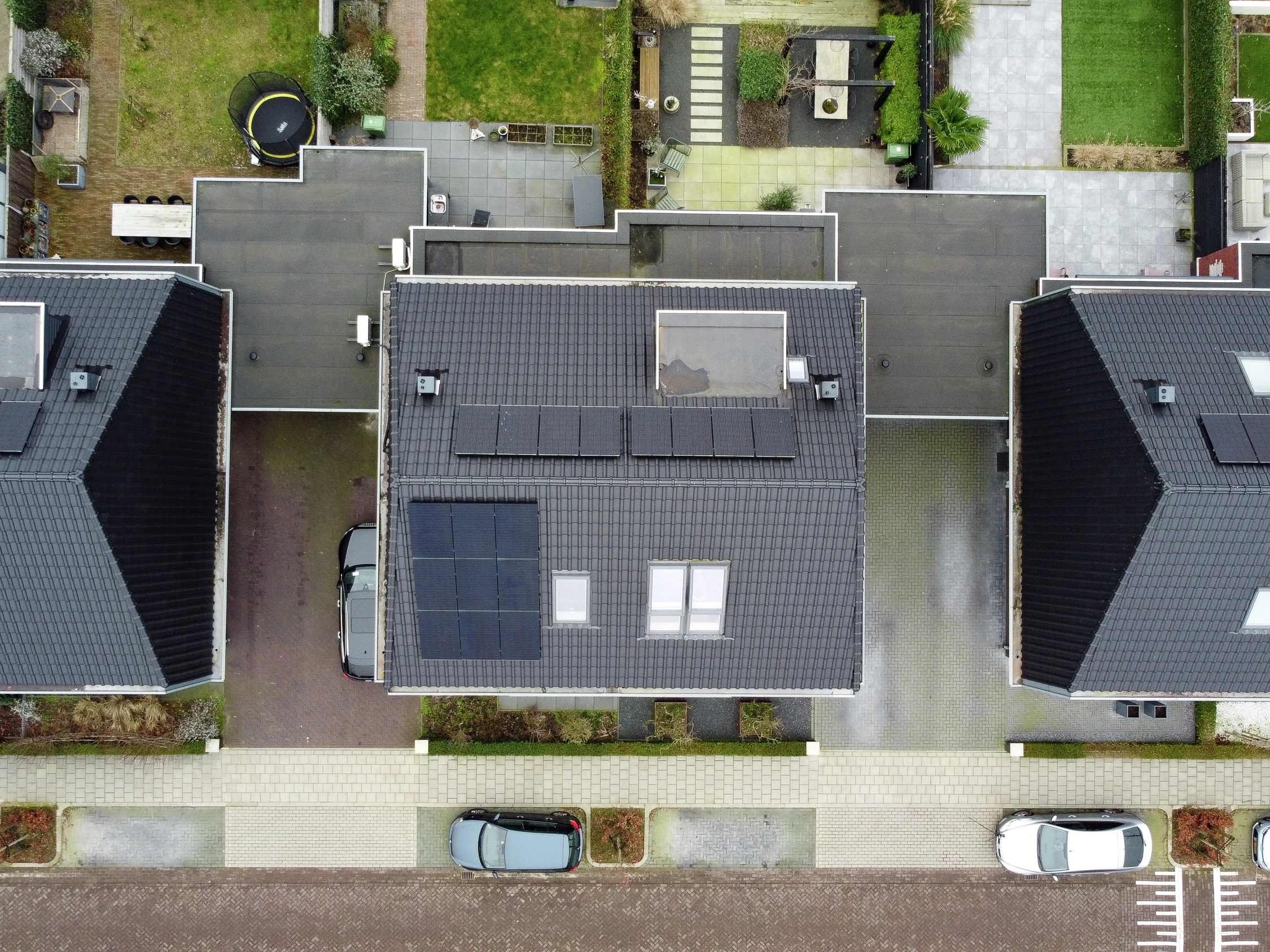 Luchtfoto van woonhuizen met zonnepanelen en VELUX dakramen.