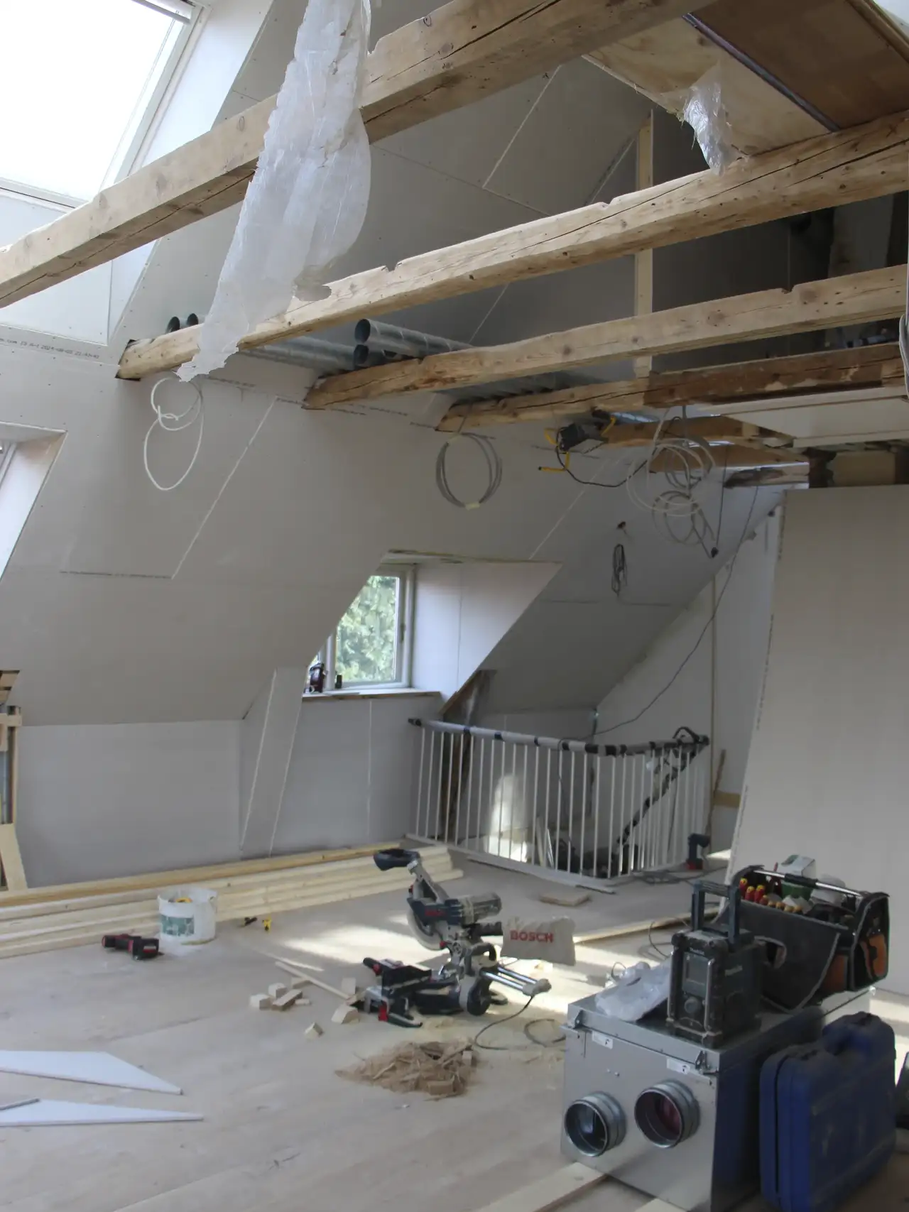Attic under renovation with visible rafters and VELUX roof window.