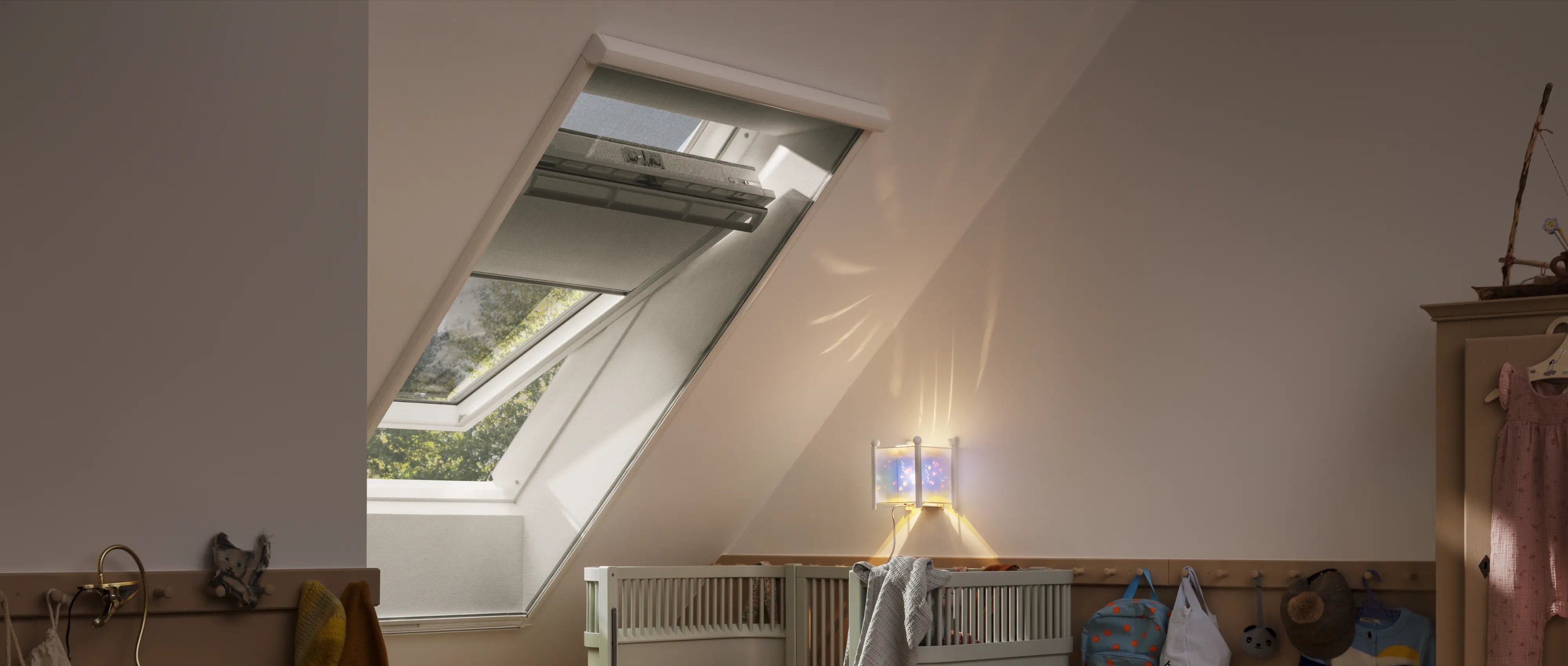 Attic kids room with sloped ceiling and VELUX roof window, cozy decor.