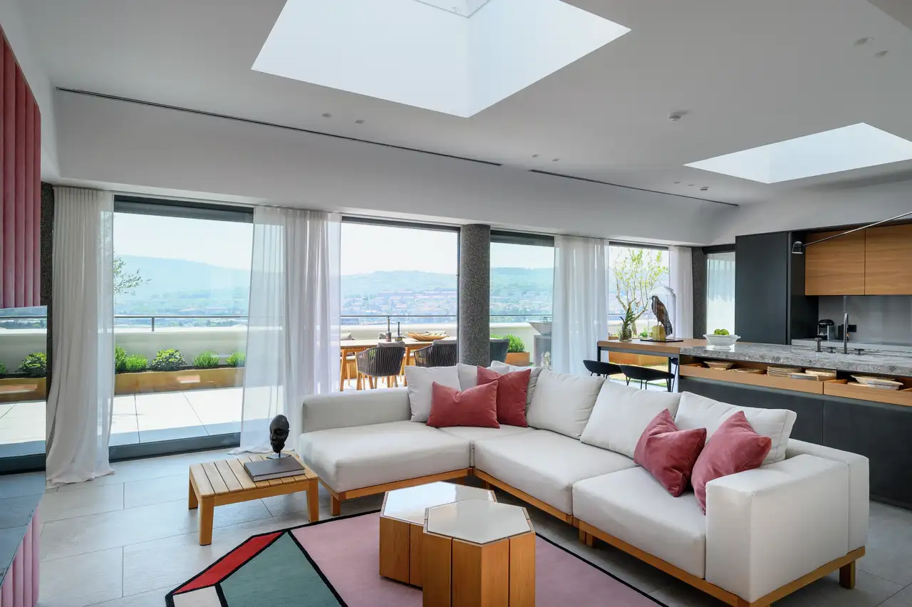 Ampio open space con grandi porte finestre affacciate su una terrazza e finestre per tetti piani.