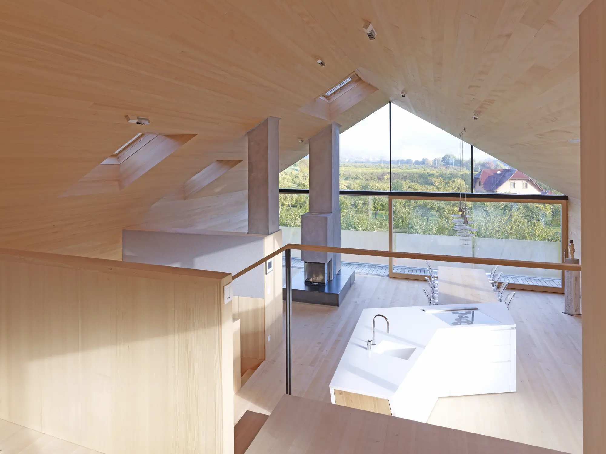 Mansardă spațioasă cu tavan înclinat, ferestre VELUX și mobilier modern.