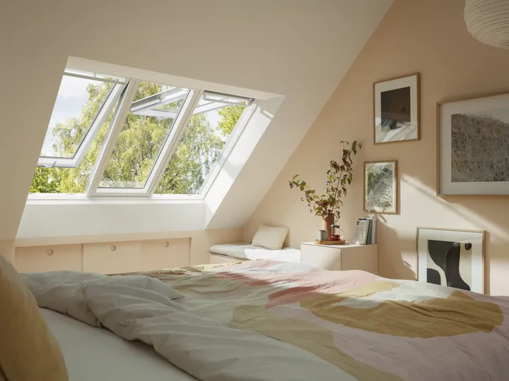 Weit geöffnete Dachfenster lüften pastellfarbenes Schlafzimmer | VELUX Magazin