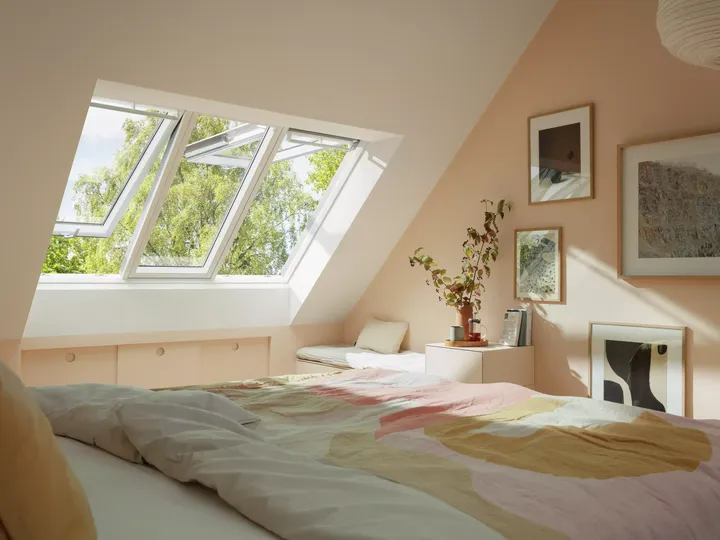 Gemütliches Schlafzimmer im Dachboden mit natürlichem Licht von VELUX Dachflächenfenstern, Pastellfarben und moderner Einrichtung.