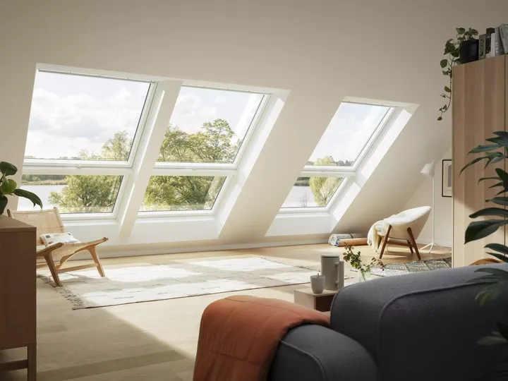 Gemütliches Wohnzimmer im Dachboden mit natürlichem Licht von VELUX Dachflächenfenstern und stilvoller Einrichtung.