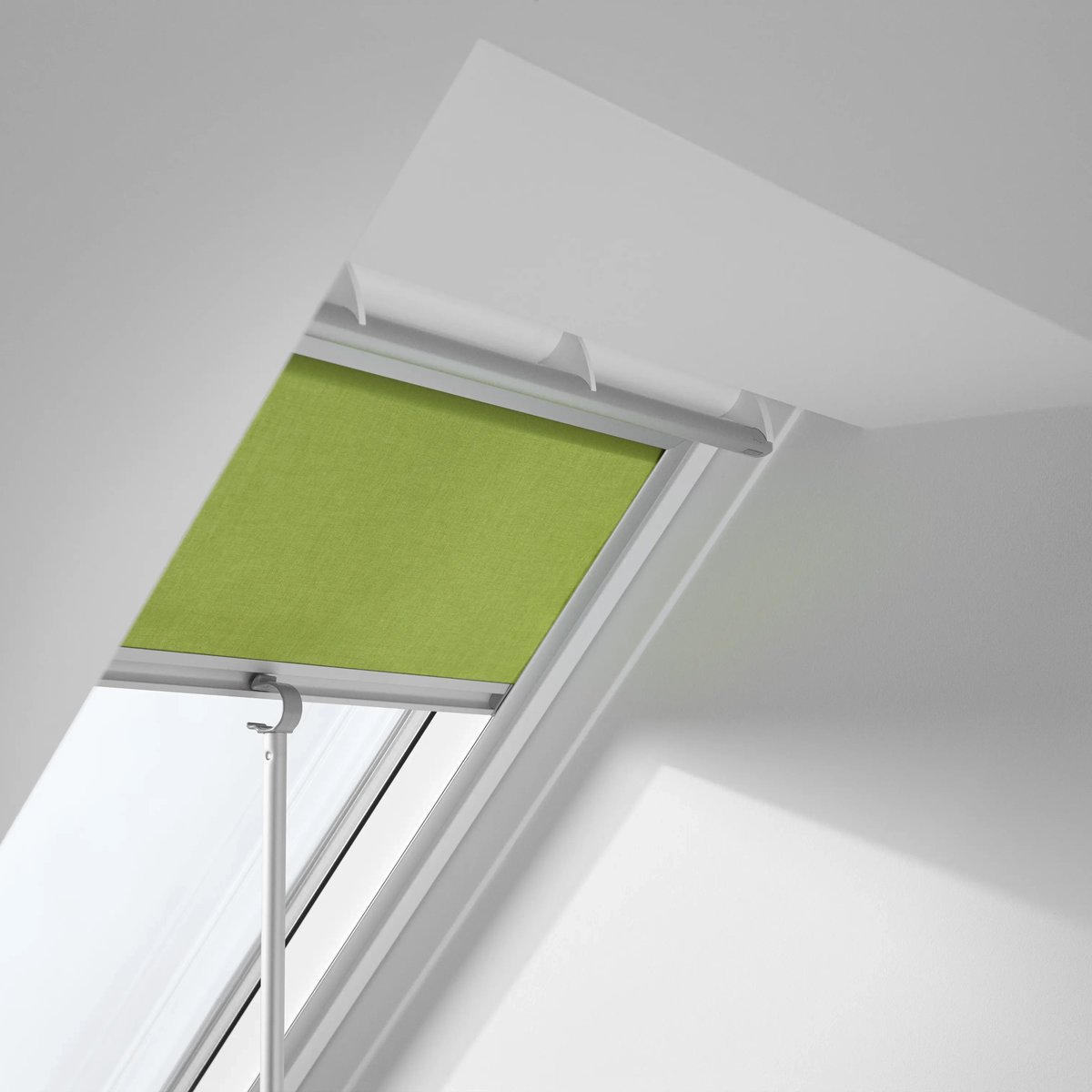 VELUX roof window with green blind in a modern attic space.