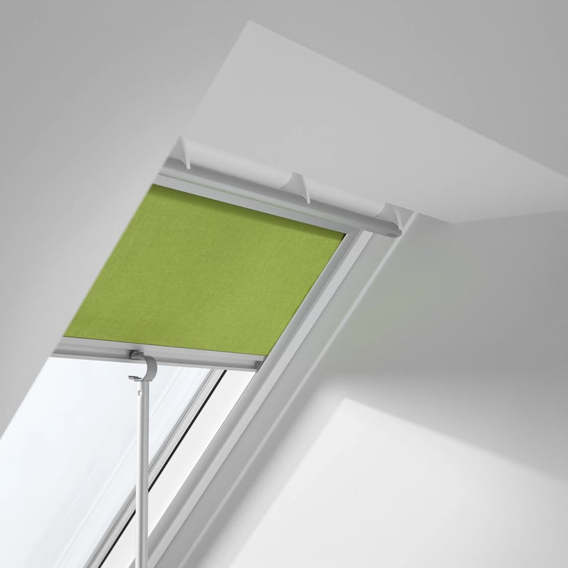 VELUX roof window with green blind in a modern attic space.