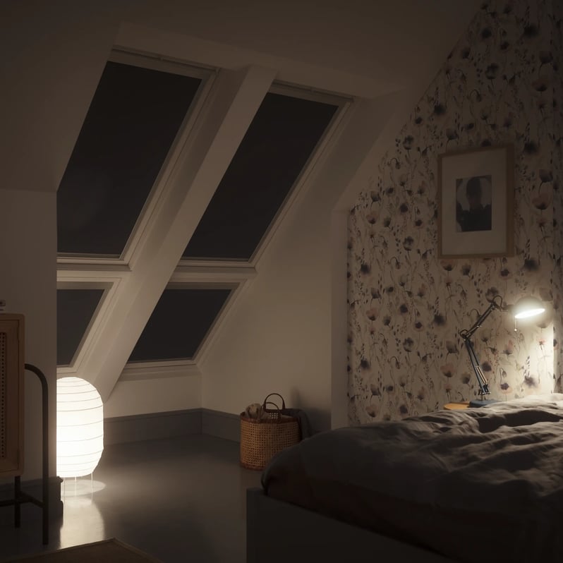 Attic bedroom with sloped ceiling and VELUX roof window, cozy ambiance.