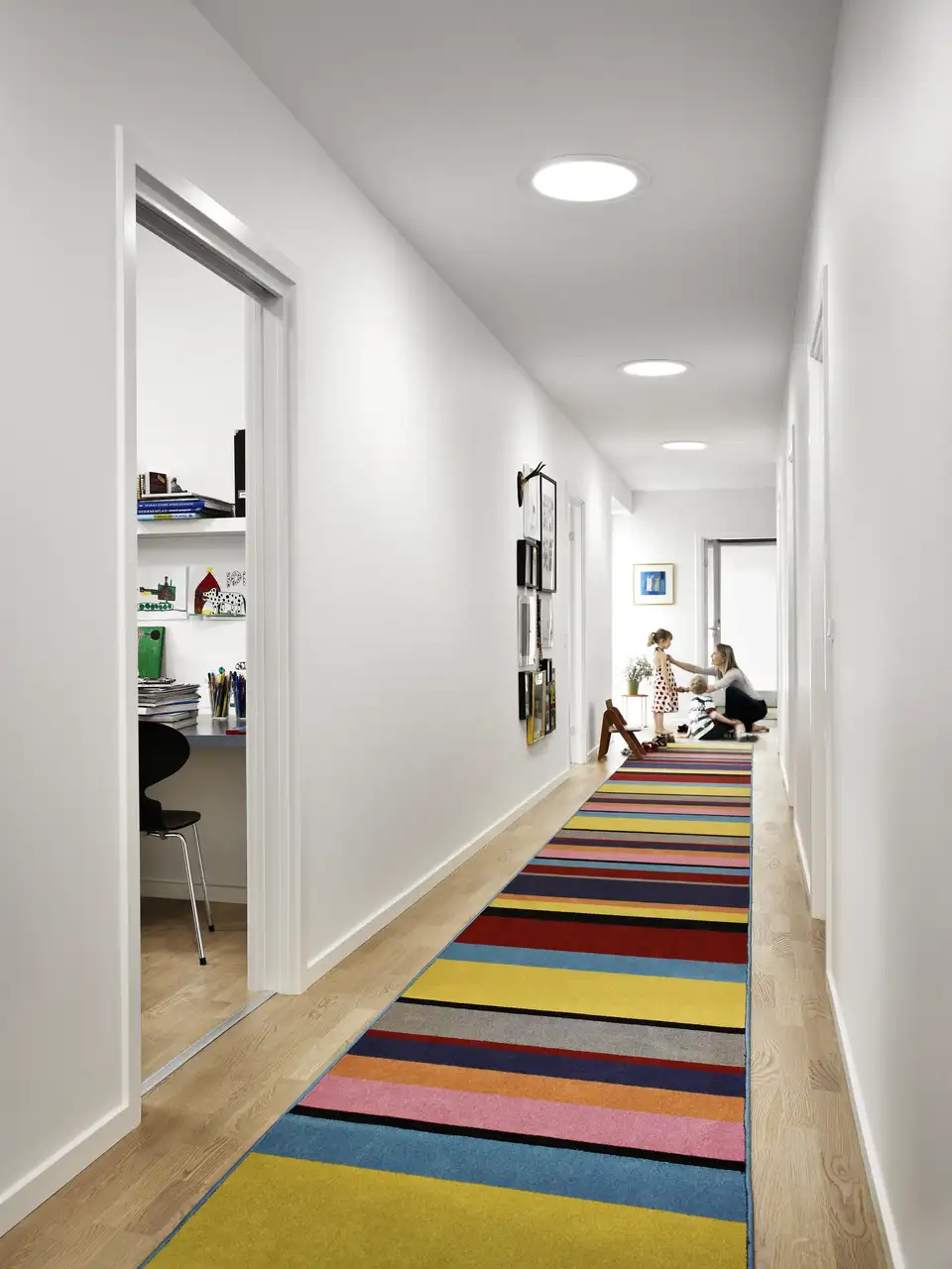 Couloir éclairé par un puits de lumière VELUX, avec tapis coloré en style Dopamine decor.