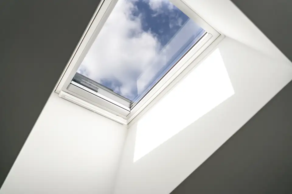 Vista do céu com a luz natural a entrar através de uma janela de telhado.