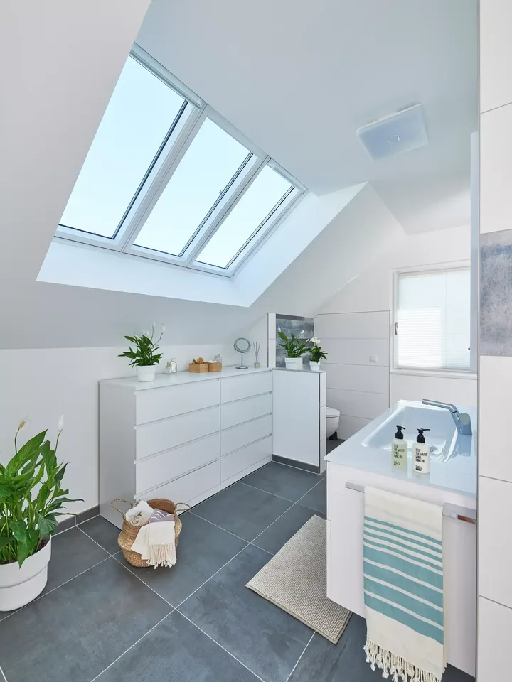 Modernes Badezimmer mit VELUX Dachflächenfenster und weißer Dekoration.