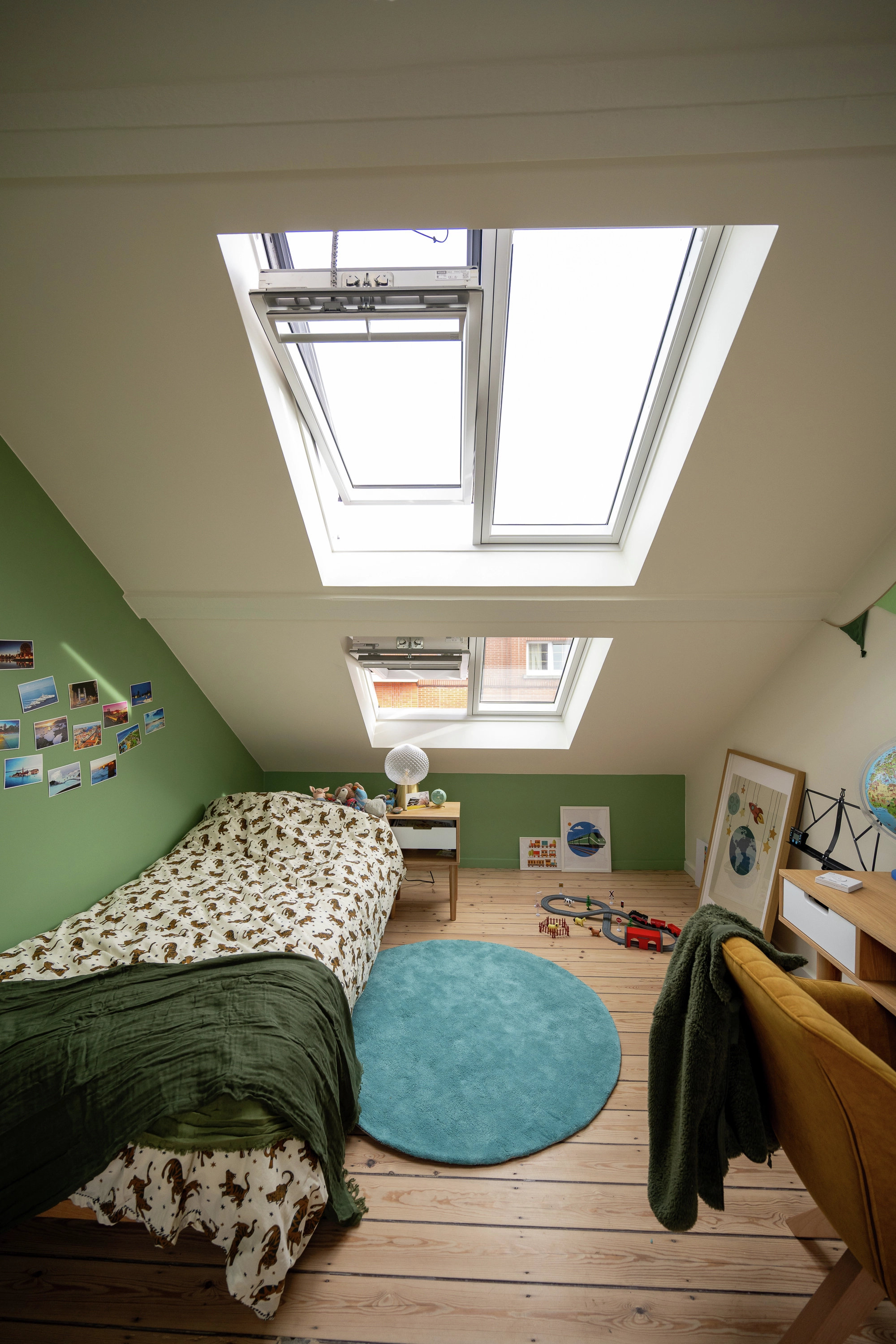 Vue de jour : lit simple sous une double fenêtre de toit 2en1 VELUX, coin bureau à droite, ambiance douce et pastel.