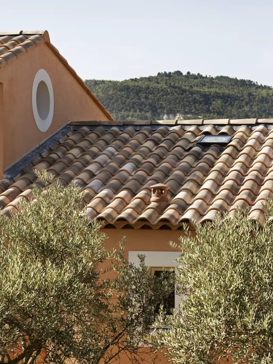 Toiture en pente avec tuiles en terre cuite et une fenêtre de toit