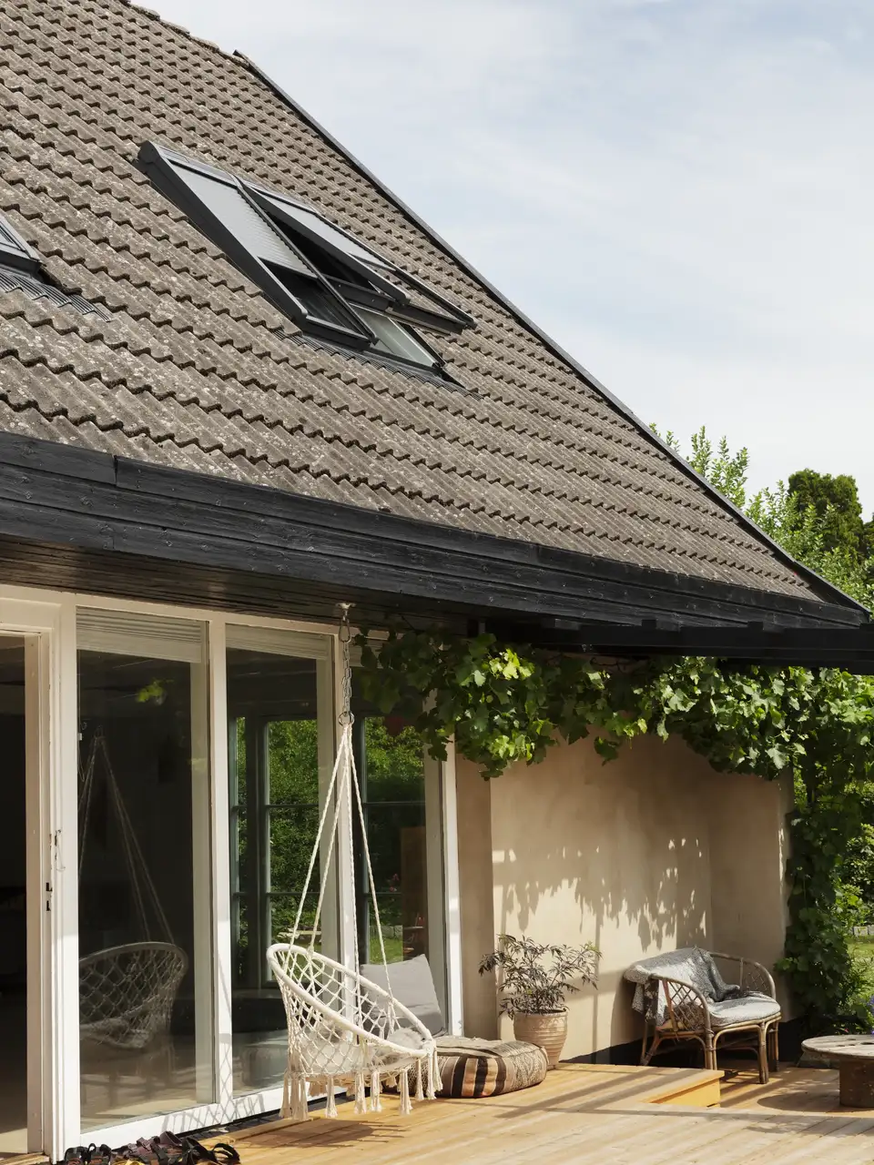 maison de campagne avec terrasse en bois, toit à deux pans et fenêtres de toit VELUX