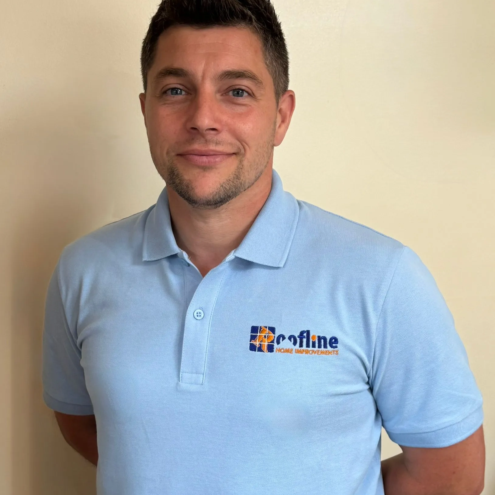 Person in blue polo with Roofline Home Improvements logo.