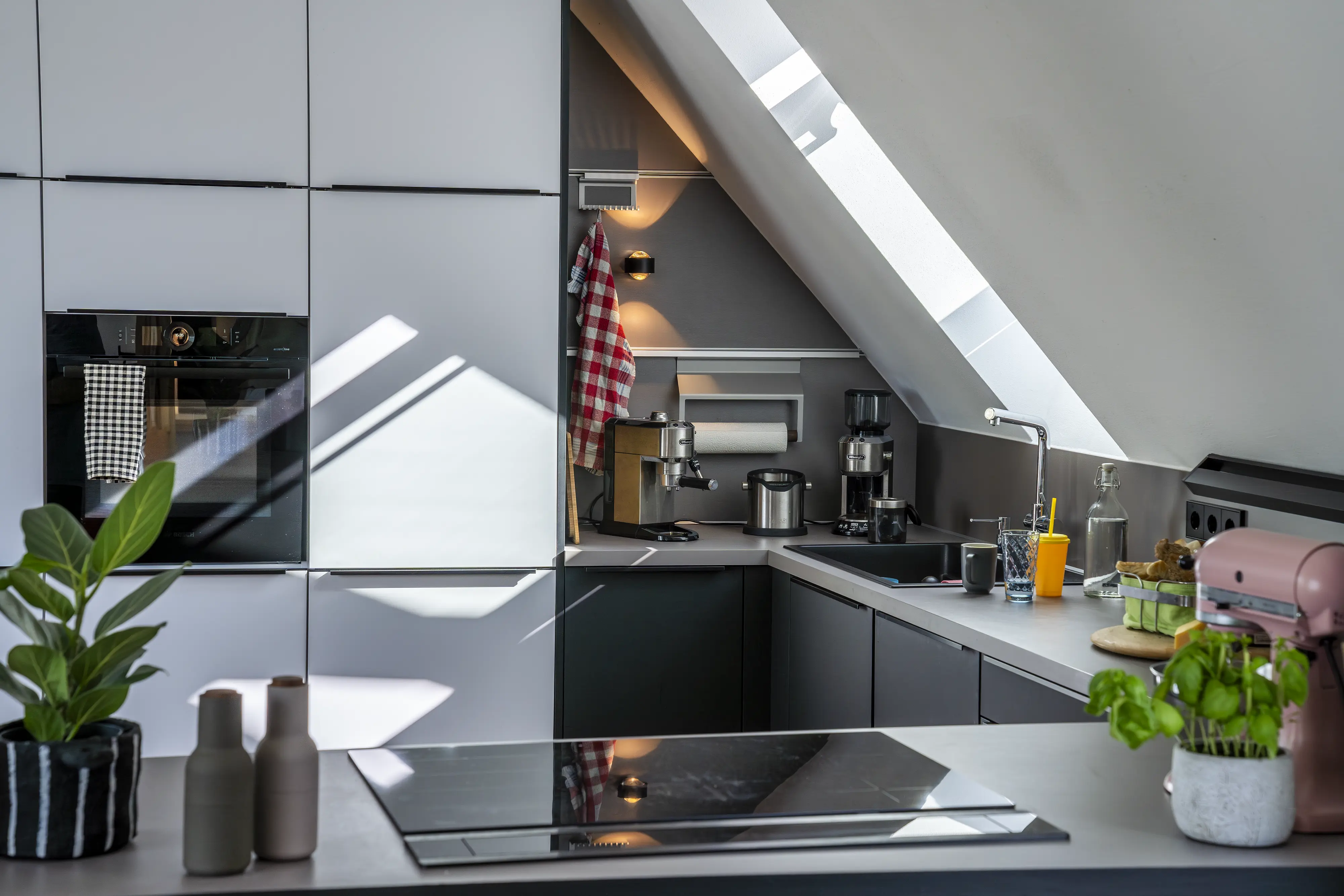 Cucina moderna in mansarda con finestra per tetti VELUX posizionata sul piano di lavoro in corrispondenza del lavello