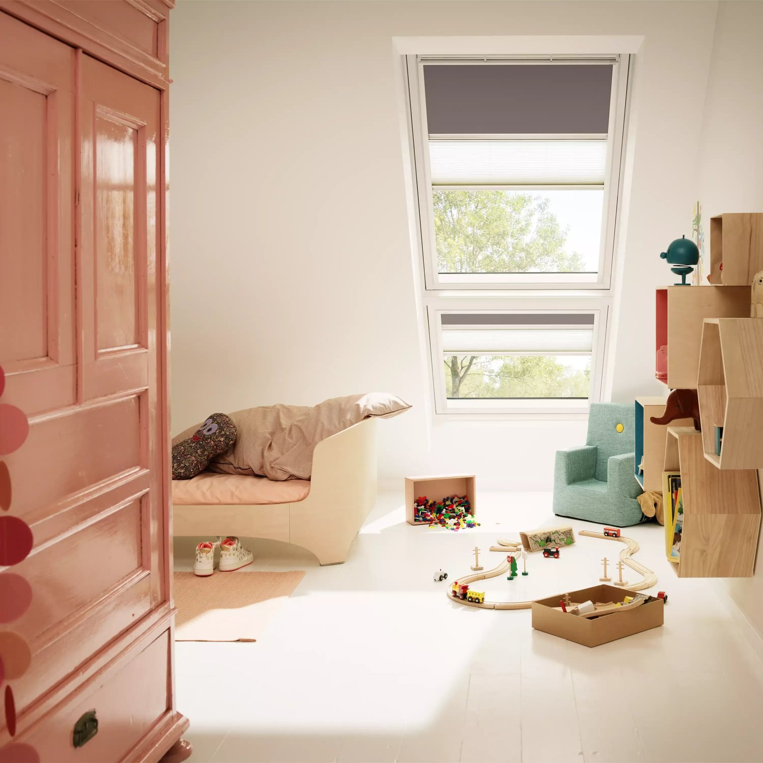 Attic kids room with sloped ceiling and VELUX roof window, playful decor.
