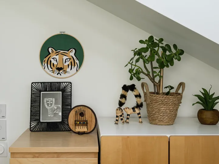 Heimbüroregal mit Tigerkunst, gerahmter Zeichnung, Nähset und Pflanzen.