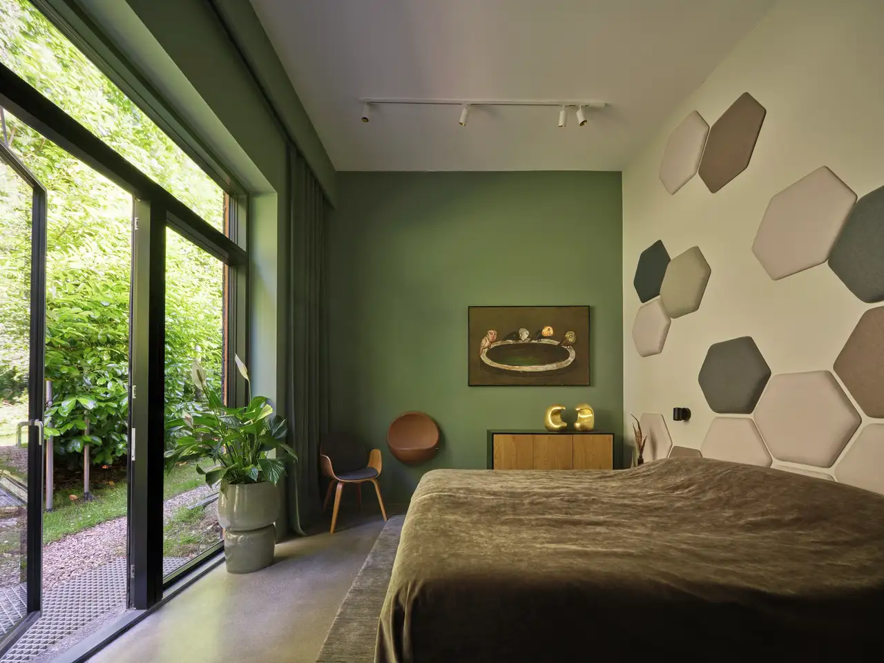 Bedroom with large window, garden view, hexagonal wall panels.