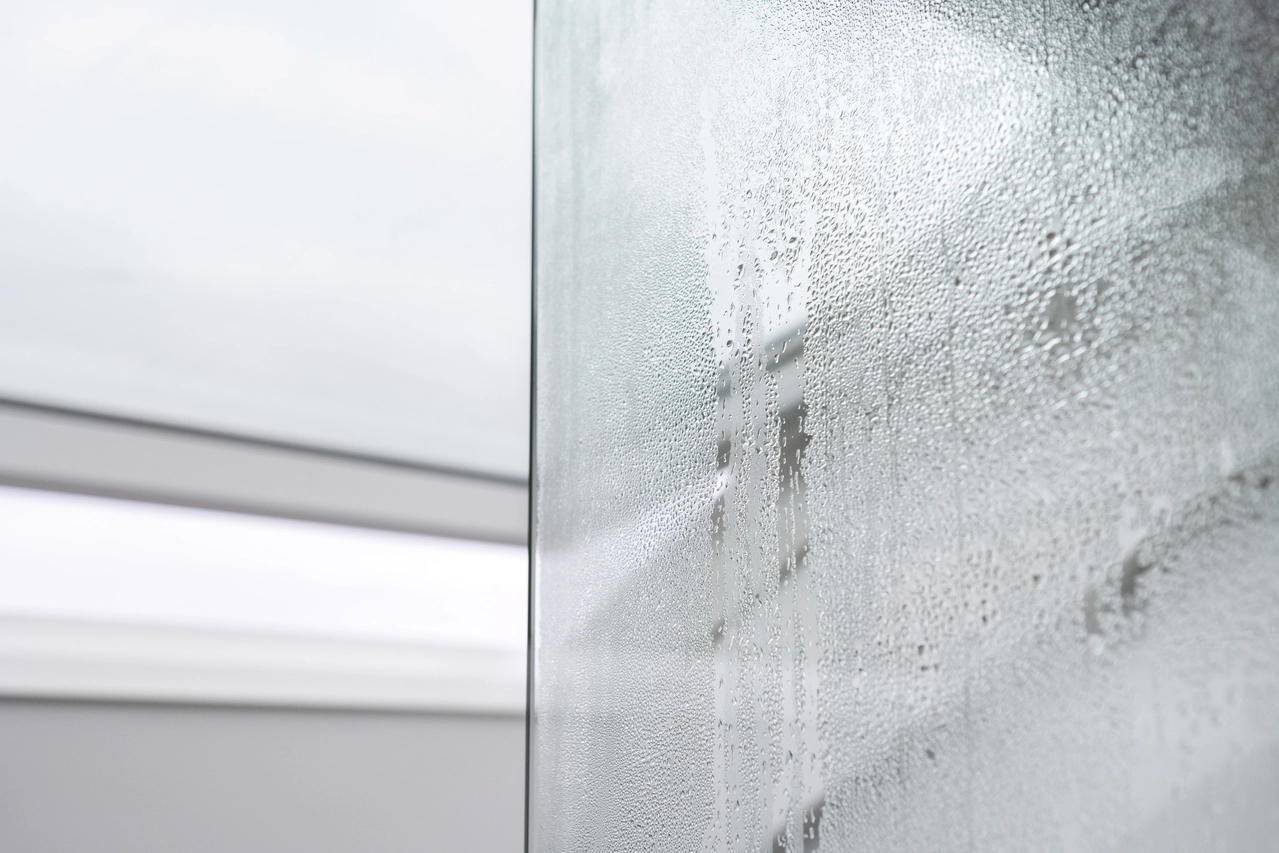 Close-up of condensation droplets on a glass surface, creating a textured pattern.