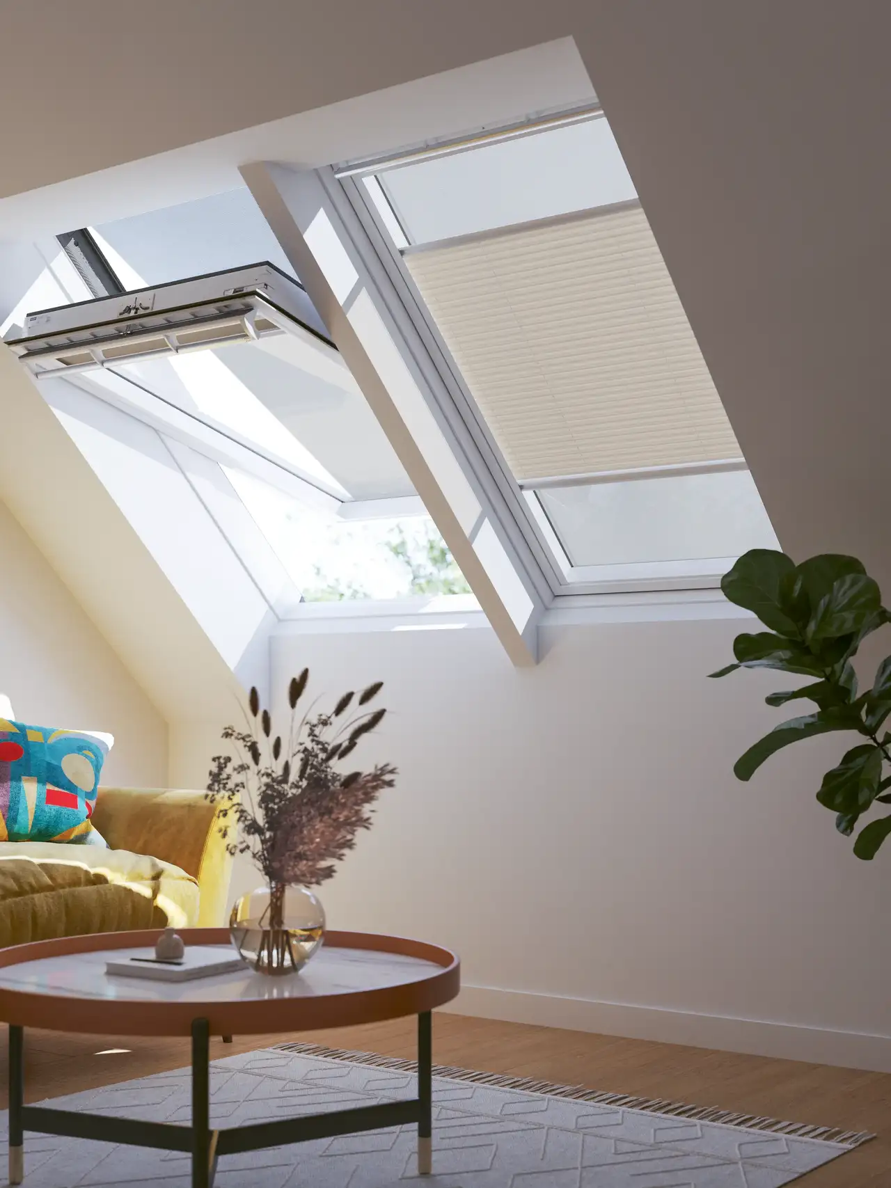 Mansarda luminosa con finestre per tetti e tende VELUX, divano giallo e arredi moderni con piante