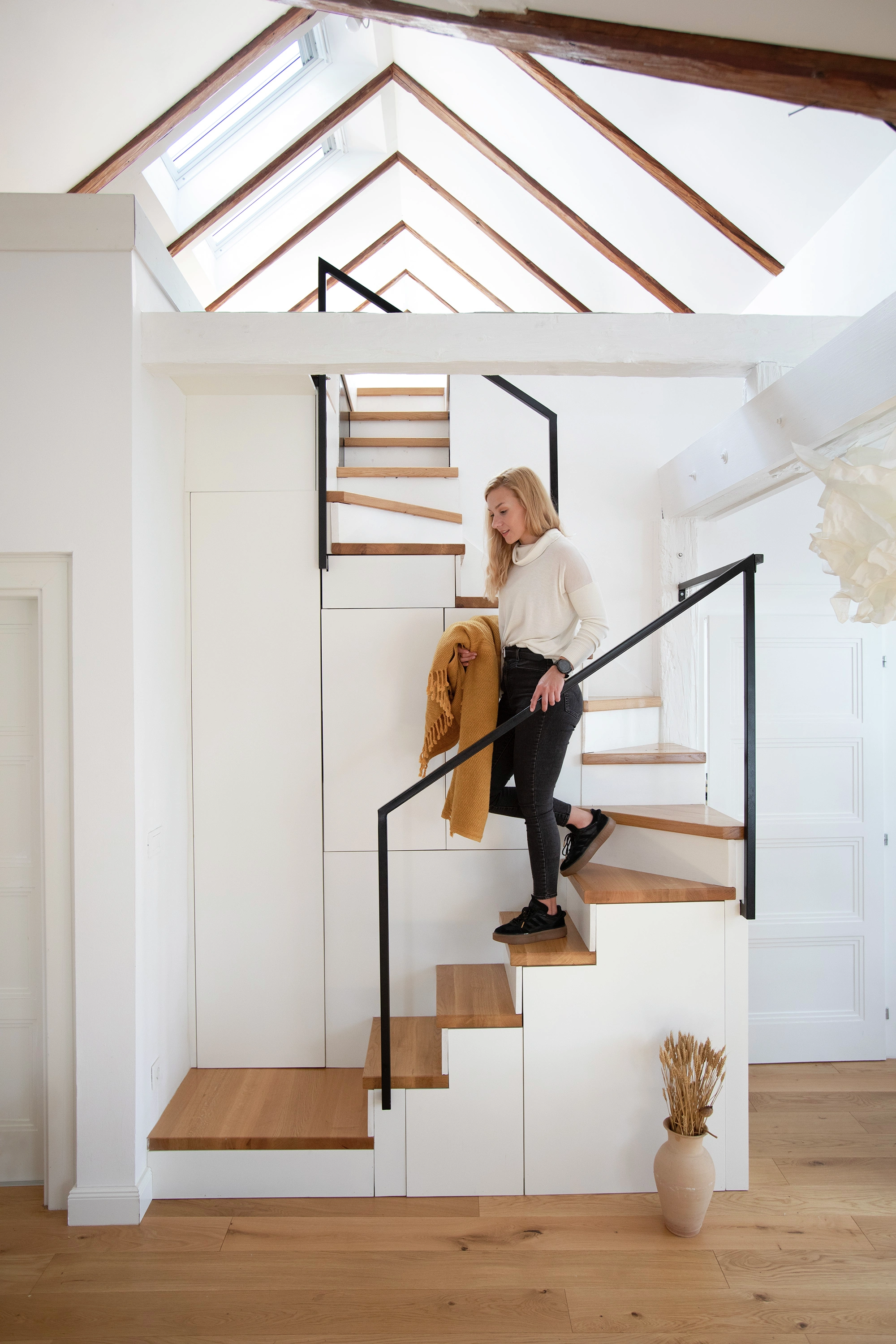 Modernas kāpnes ar koka pakāpieniem un VELUX jumta logiem.