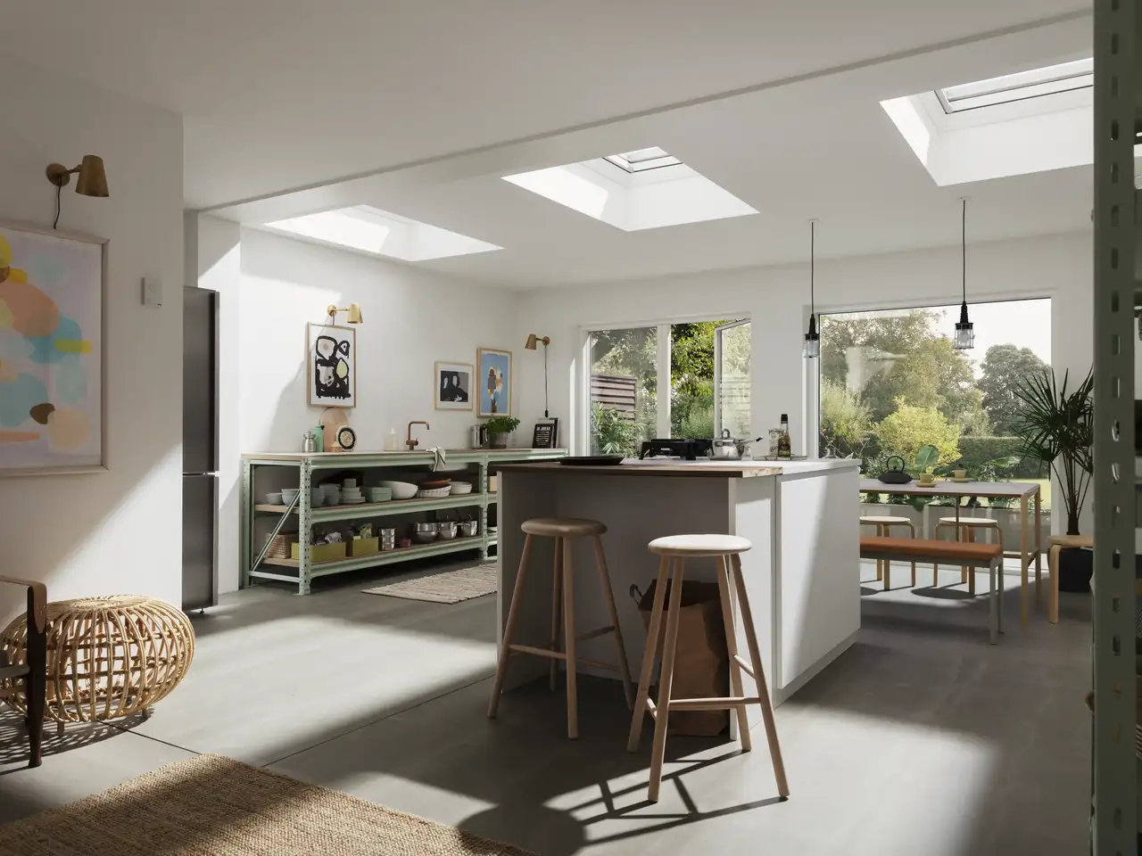 Cucina moderna con tre finestre per tetti piani VELUX, isola centrale e vista sul giardino da grandi porte finestre.