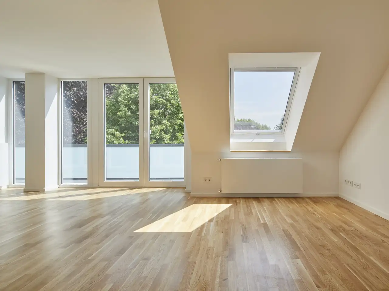 Mansarda spaziosa con finestre verticali e una finestra per tetti VELUX, luminosa e ariosa.