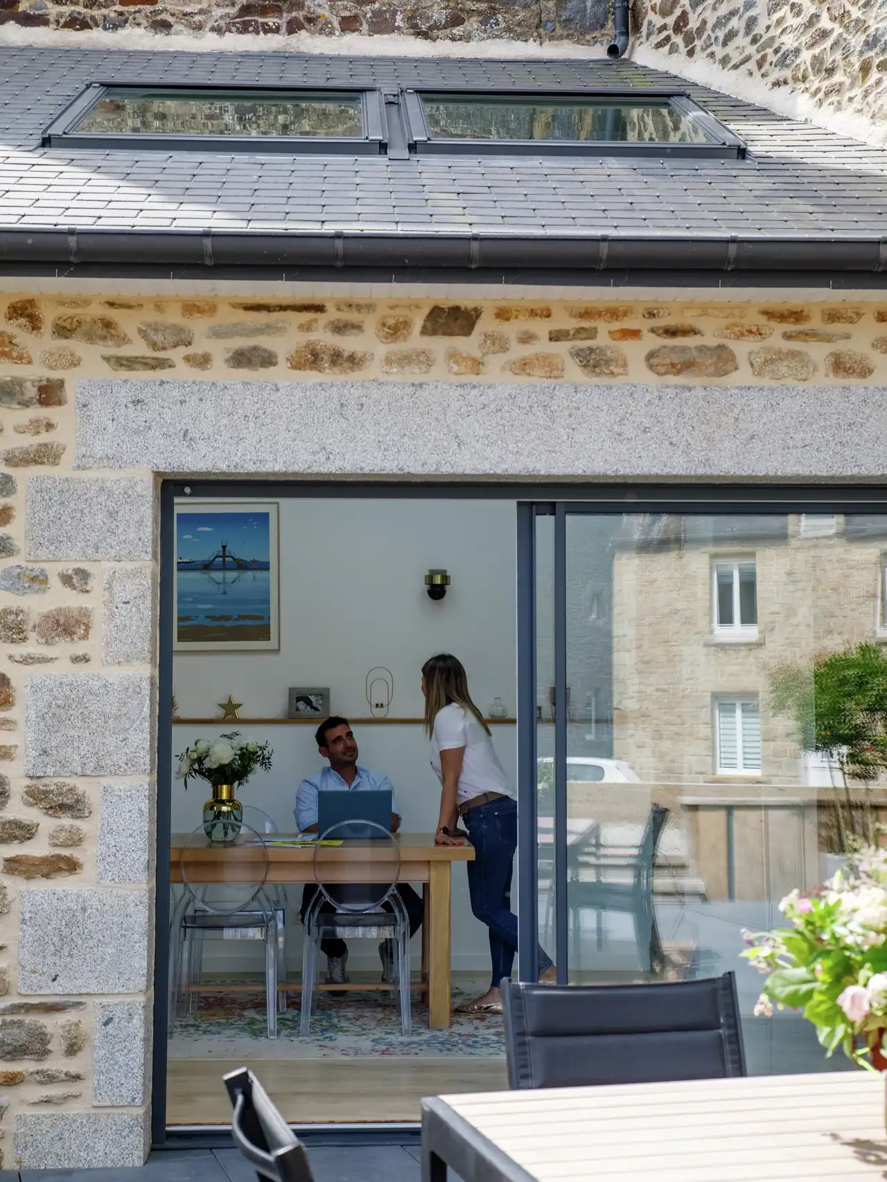 Maison en pierre avec baie vitrée et fenêtres de toit