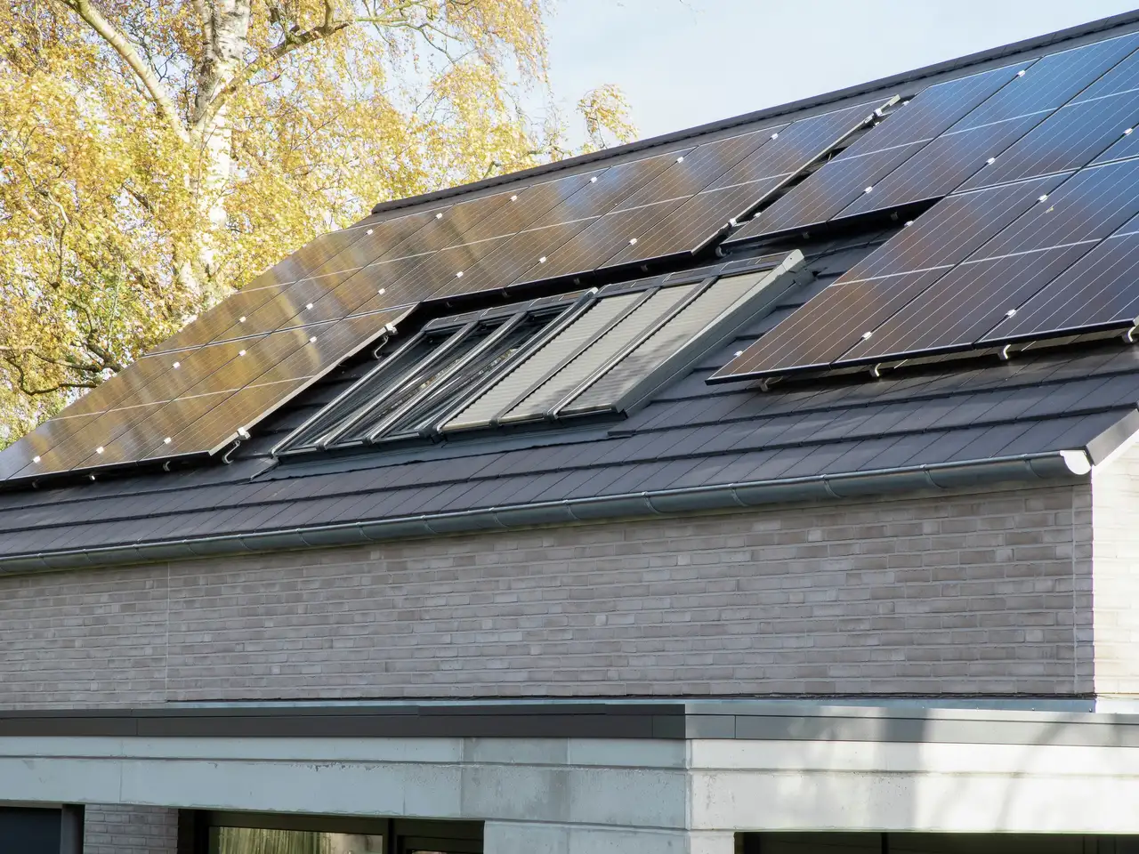 Vista esterna di un tetto a falde con impianto fotovoltaico e lucernari | Rivista VELUX
